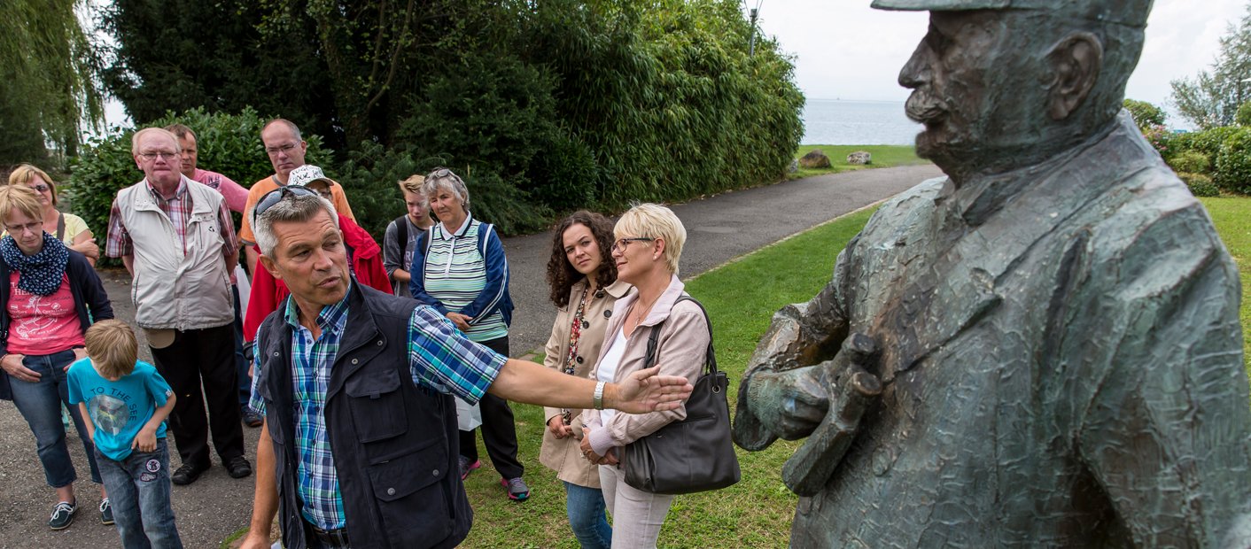 Menschen bestaunen Graf Zeppelin Statue