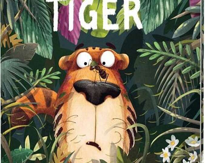 Der Tiger sitzt im Gebüsch und beobachtet eine Ameise, die über seine Nase läuft.