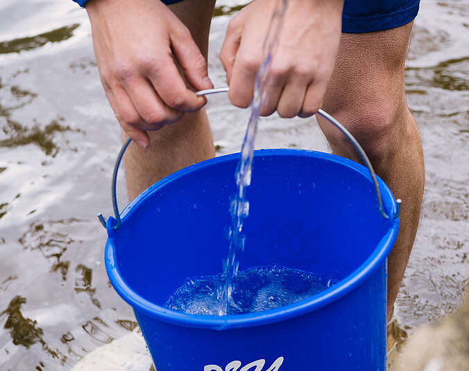 Mensch, der einen Eimer Wasser trägt. (Foto: Para 2025 )