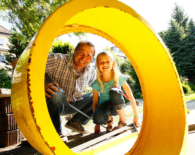 Vater und Tochter beim Minigolf