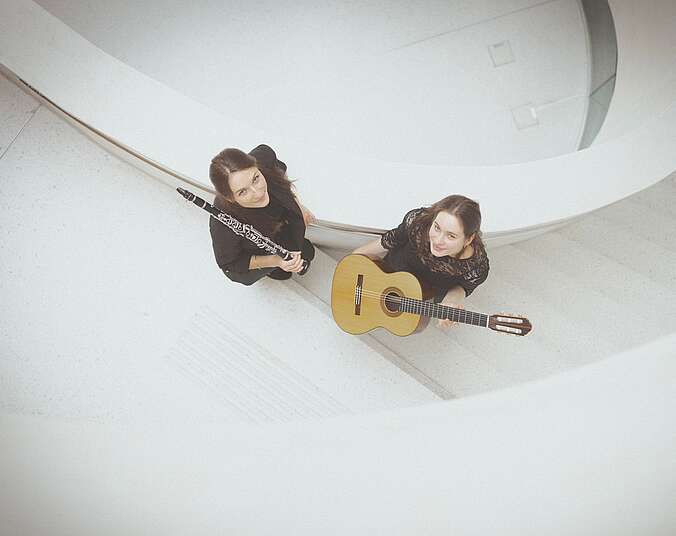 Weißes Treppenhaus mit zwei Musikerinnen auf den Stufen. (Foto: Jana Stetter )