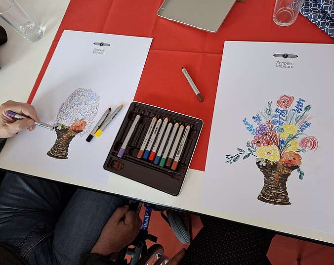 zwei weißte Blätter, auf die jeweils ein Blumenstrauß mit Wachsaquarell gemalt wurde