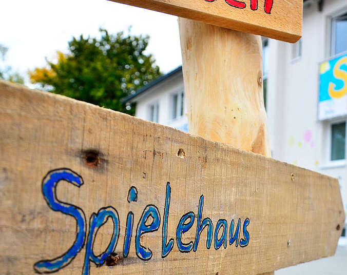 Holzschild mit der Aufschrift "Spielehaus"