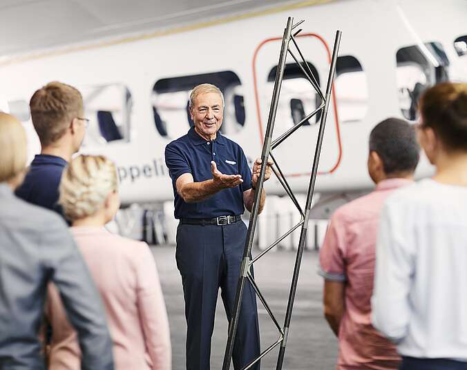 Männer und Frauen stehen im Zeppelin Hangar.
