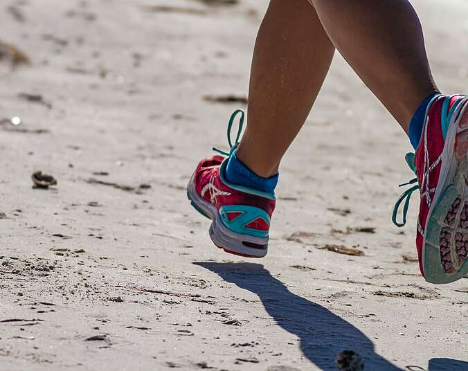 Person mit blau-weißen Turnschuhen