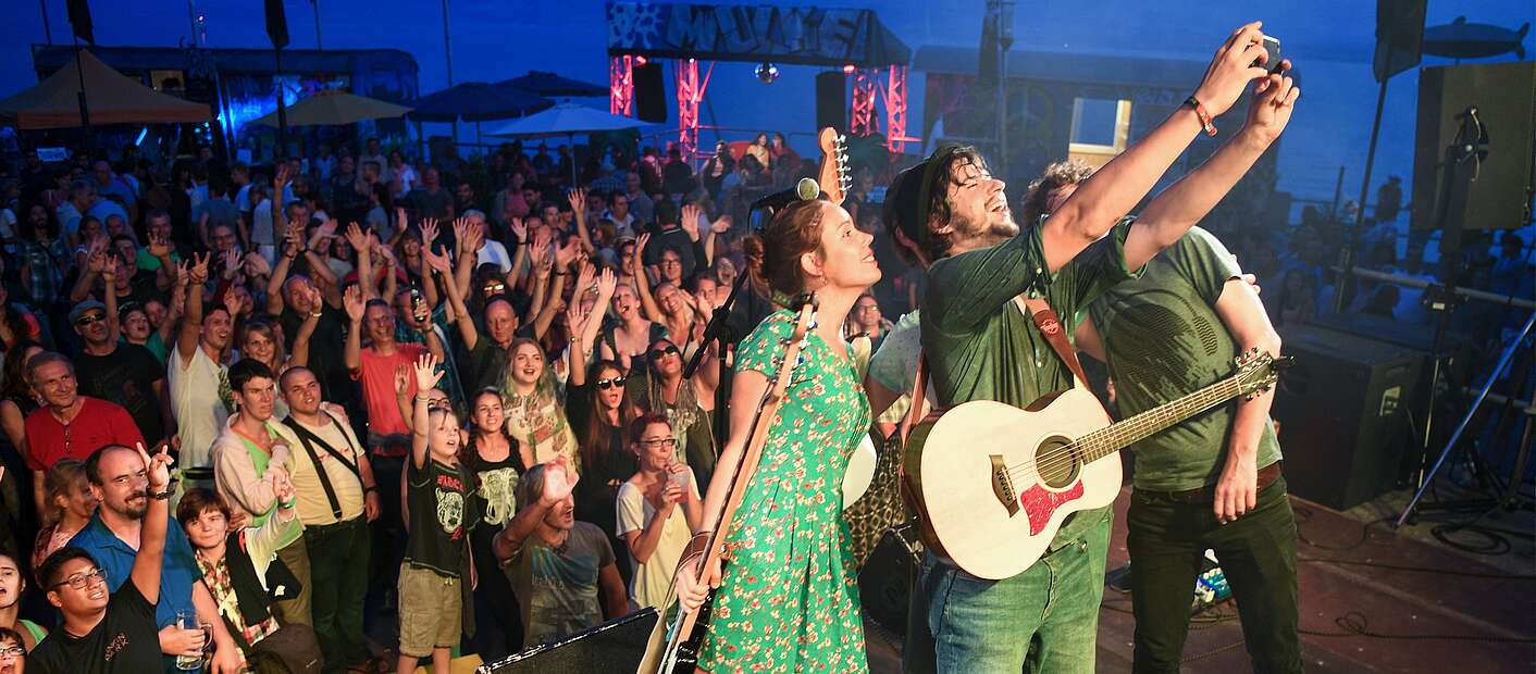 Band feiert auf Bühne am See