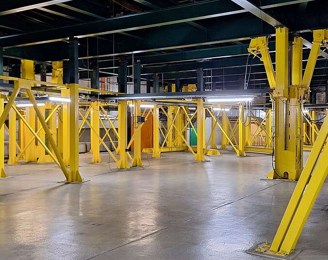 Ein Raum ohne Fenster; die Raumdecke wird getragen von zahlreichen gelb gestrichenen Hydraulikstempeln.