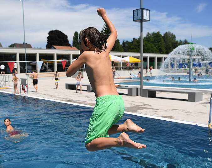 Kind springt ins Wasser im Frei und Seebad Fischbach