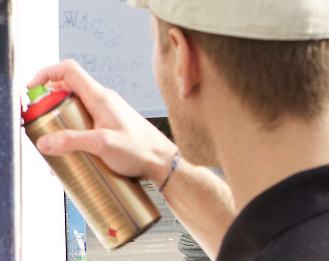 Mann hält eine Spraydose in der Hand