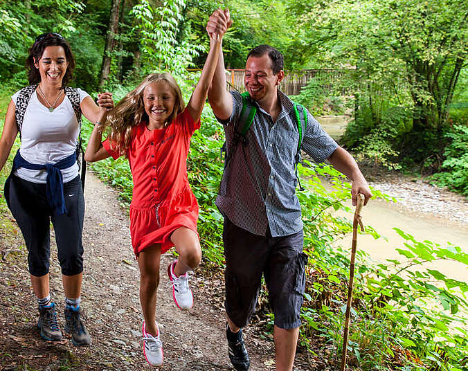 Familie wandert am Bach entlang