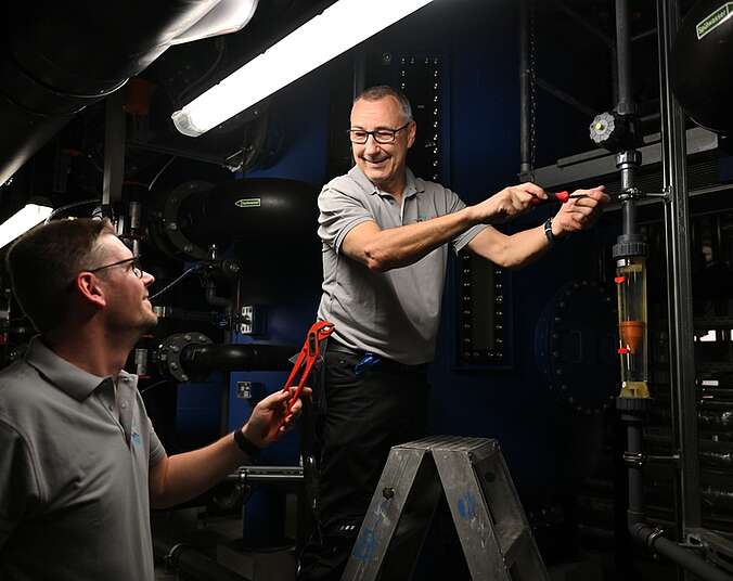 Zwei Männer arbeiten an einer technischen Anlage