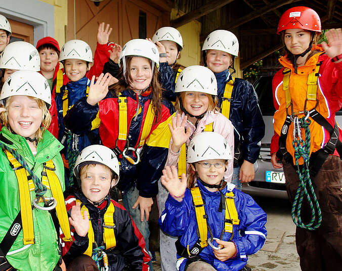 Kinder mit Helm und Klettersicherung